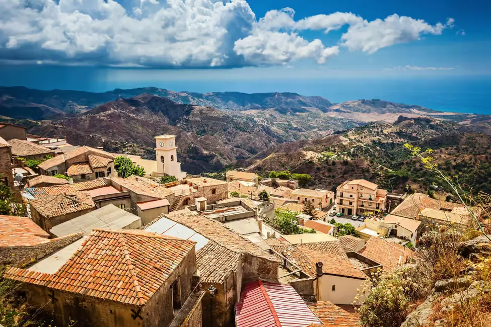 Trekker overlooking Pentedattilo village set against rugged Aspromonte rocks