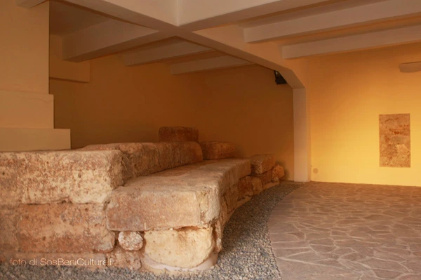 Ruins of the Odeon in Reggio Calabria with sandstone steps and Ionic terracotta capitals, showcasing Greek archaeology.